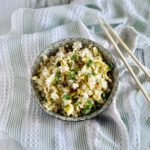 bowl of fried rice containing eggs, soy sauce, green onions and salt and pepper to taste