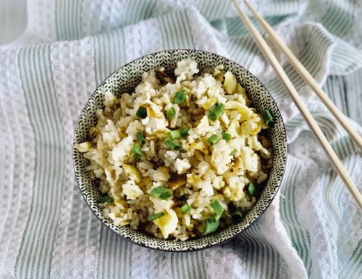 bowl of fried rice containing eggs, soy sauce, green onions and salt and pepper to taste